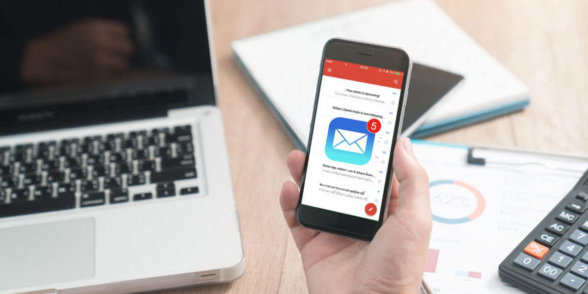 a-quoi-sert-email-marketing Une personne reçoit un nouveau message sur son téléphone et ouvre sa boite mail pour le lire.